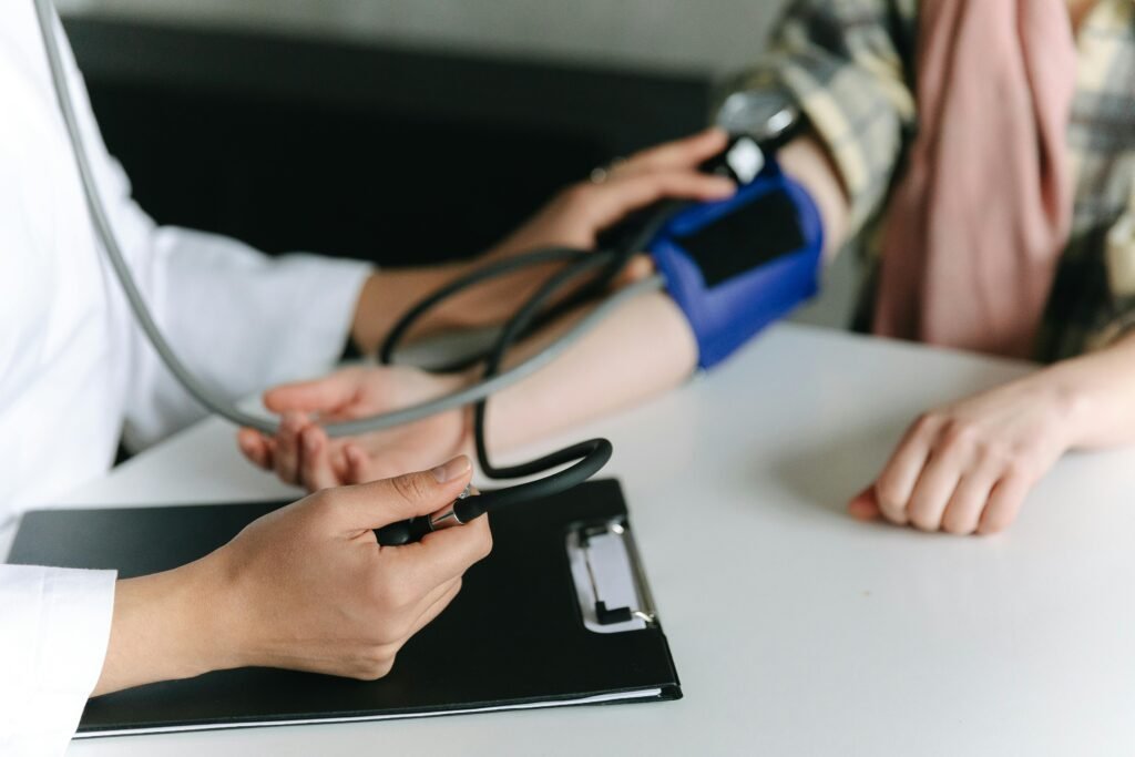 pexels-photo-7659564-7659564 Close-up of a medical professional measuring a patient's blood pressure at a clinic.